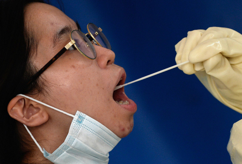 Seorang wanita menjalani ujian COVID-19 di sebuah stesen ujian, di Kota Makati, Metro Manila.