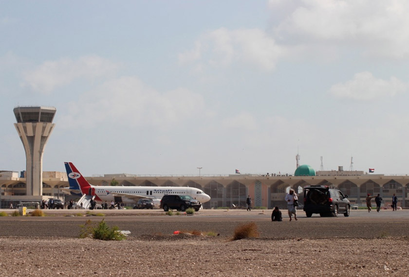 Bystanders stand near the runway of Yemen southern city of Aden’s airport shortly after an explosion hit as a government plane landed, Wednesday, Dec. 30, 2020. The blast struck the airport building shortly after a Yemenia airlines plane carrying the newly formed Cabinet landed. No one on the government plane was hurt. (AP Photo/Wael Qubady)