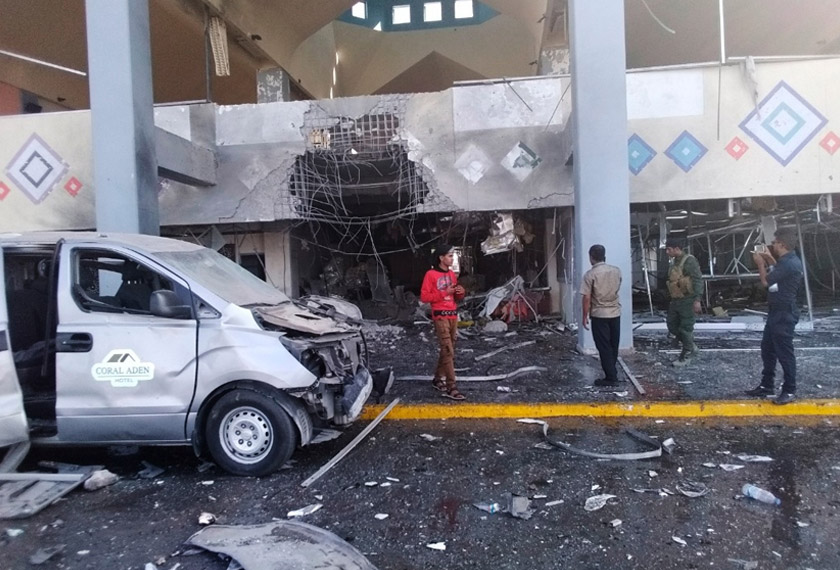 Bystanders and a soldier stand near a damaged portion of the airport of Yemen’s southern city of Aden’s after an explosion, Wednesday, Dec. 30, 2020. The blast struck the airport building shortly after a plane carrying the newly formed Cabinet landed on Wednesday. No one on the government plane was hurt. (AP Photo/Majid Saleh)