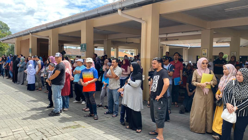 Ibu bapa yang sedang menunggu anak-anak mereka masuk ke kelas sambil meningar taklimat daripada guru bertugas. - Astro AWANI/ISABELLE LEONG