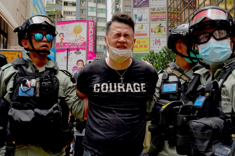 Police detain a protester after spraying pepper spray during a protest in Causeway Bay before the annual handover march in Hong Kong, Wednesday, July. 1, 2020. Hong Kong marked the 23rd anniversary of its handover to China in 1997, and just one day after China enacted a national security law that cracks down on protests in the territory. (AP Photo/Vincent Yu)