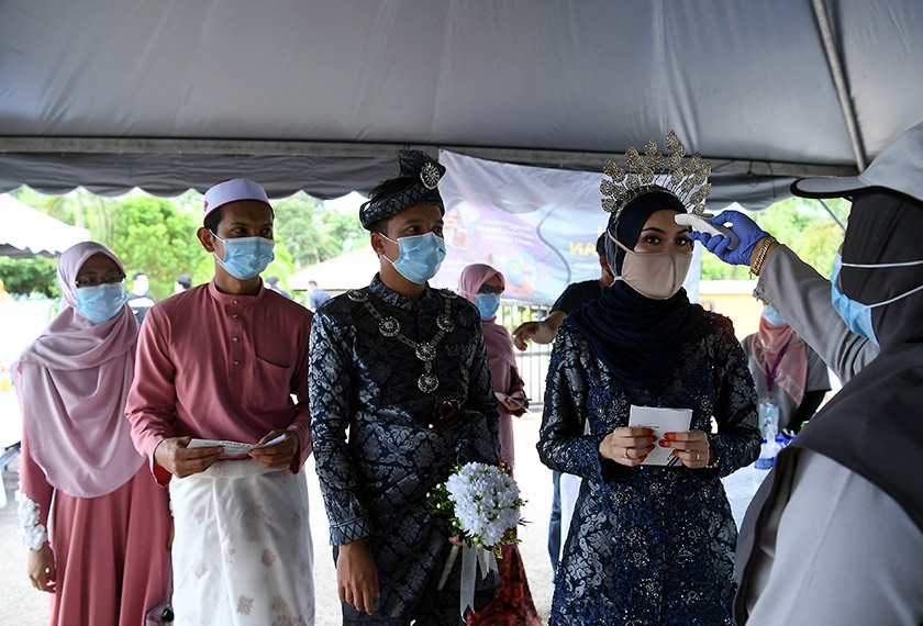 Pengantin yang mengadakan majlis resepsi hari ini sempat menunaikan tanggungjawab mengundi. -Bernama