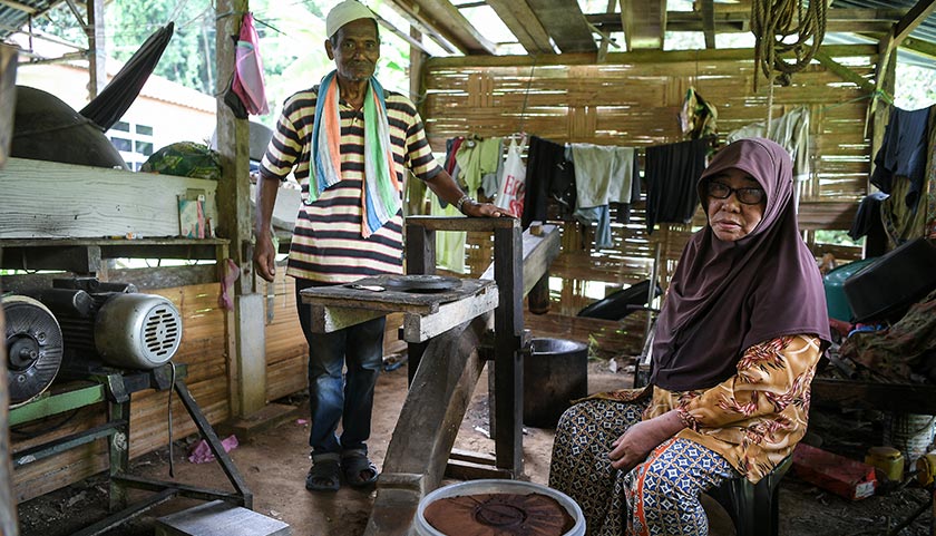 Mohd Sabiah bersama isterinya menunjukkan lesung hindik yang berusia kira-kira 40 tahun yang digunakan sehingga hari ini bagi menghasilkan serbuk kopi di Kampung Belantik Dalam, di Sik. --fotoBERNAMA