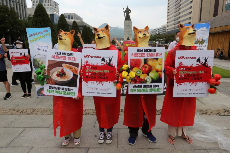 South Korean vegetarian activists wearing dog masks stage a rally opposing South Korea's culture of eating dog meat in Seoul, South Korea, Thursday, July 16, 2020. Activists wore dog masks and held a mock funeral for a canine during their protests against dog meat consumption in South Korea on Thursday, the first of three