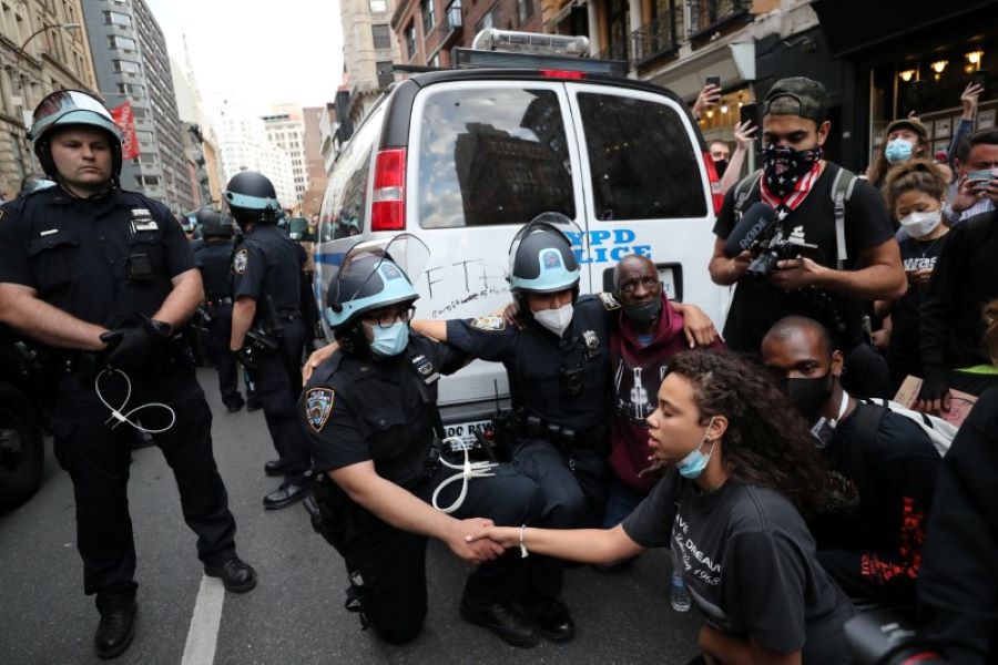 Police officers take a knee with demonstrators during a protest against the death in Minneapolis police custody of George Floyd, in the Manhattan borough of New York City, U.S., June 2, 2020. REUTERS/Jeenah Moon