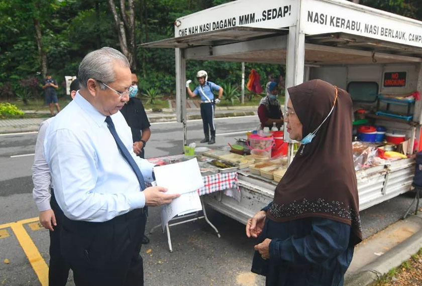Tan Sri Annuar Musa mengambil keputusan untuk menyerahkan sendiri Lesen Penjaja Beredar itu kepada Minah yang turut dikenali sebagai Che Nah di lokasi dia berniaga di Bukit Damansara di sini. - Foto Wilayahku
