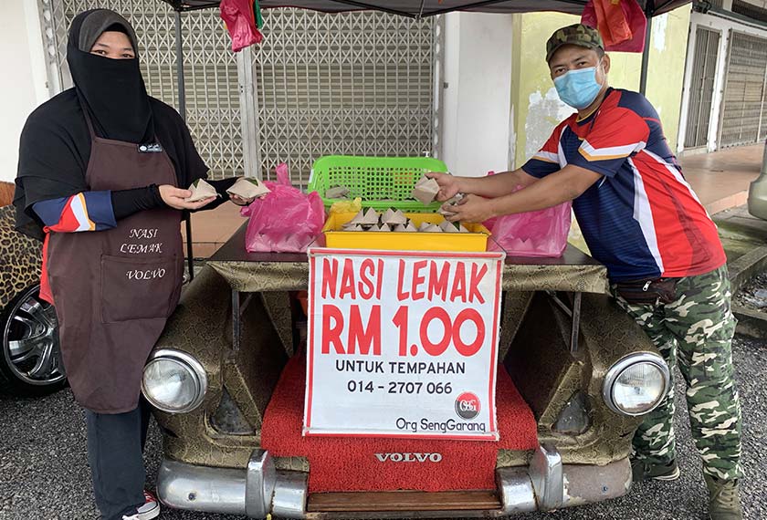 Peminat kereta klasik Volvo 122 Amazon yang juga peniaga nasi lemak RM1, Mohsin Yusop, 40 (kanan) dan isterinya, Norazlina Jaafar, 38, menunjukkan hasil kerjanya yang merupakan bahagian hadapan kereta berkenaan yang digabungkan dengan bahagian belakang motosikal Modenas Jaguh. - Foto BERNAMA
