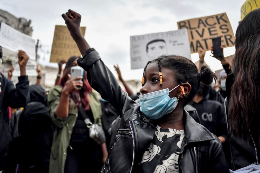 A girl clinches her fist as people gather to honor George Floyd, who died May 25 after being restrained by police in Minneapolis, USA, in Milan, Italy, Sunday, June 7, 2020. In Italy’s financial capital, Milan, a few thousand protesters gathered in a square outside the central train station Sunday afternoon to demonstrate against racism. (Claudio Furlan/LaPresse via AP)