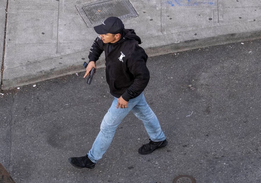 A man holds what appears to be a firearm after having driven at George Floyd protesters Sunday, June 7, 2020, in Seattle. Authorities say the man hit a barricade then exited the vehicle brandishing a pistol. At least one person was injured. The victim was a 27-year-old male who was shot and taken to a hospital in stable condition, the Seattle Fire Department said. (Dean Rutz/The Seattle Times via AP)