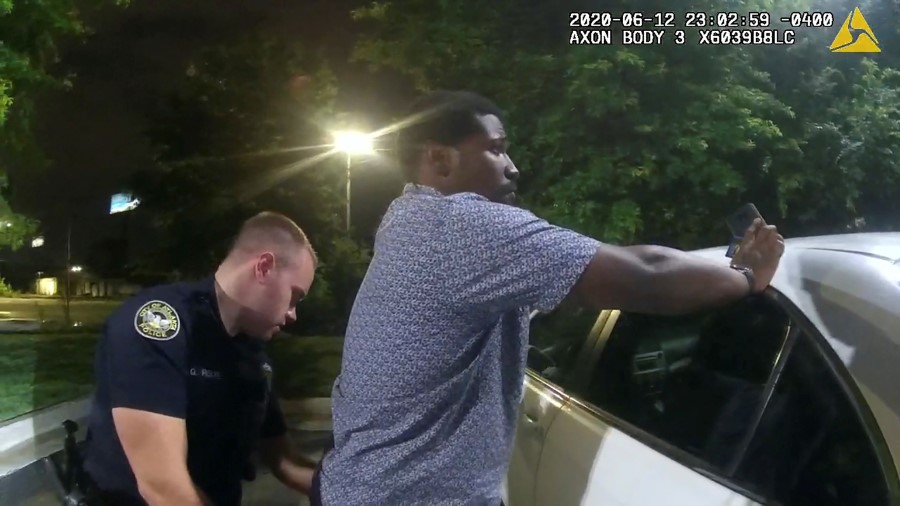 Former Atlanta Police Department officer Garrett Rolfe searches 27-year-old Rayshard Brooks in a Wendy's restaurant parking lot in a still image from the video body camera of officer Devin Bronsan in Atlanta, Georgia, U.S. June 12, 2020. Video taken June 12, 2020. Atlanta Police Department/Handout via REUTERS