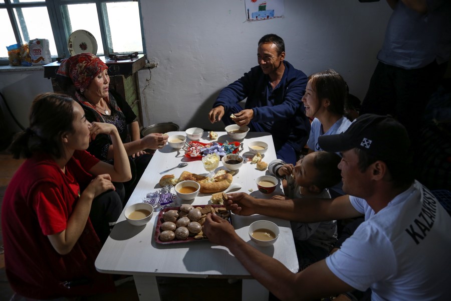 Gulnar Omirzakh, second right, and her husband, Baqytali Nur, third right, eat lunch with friends and family at their home in Shonzhy, Kazakhstan on Saturday, June 13, 2020. Omirzakh, an ethnic Kazakh, says she was forced to get an intrauterine contraceptive device when living in China, and that authorities threatened to detain her if she didn't pay a large fine for having a third child. (AP Photo/Mukhit Toktassyn)