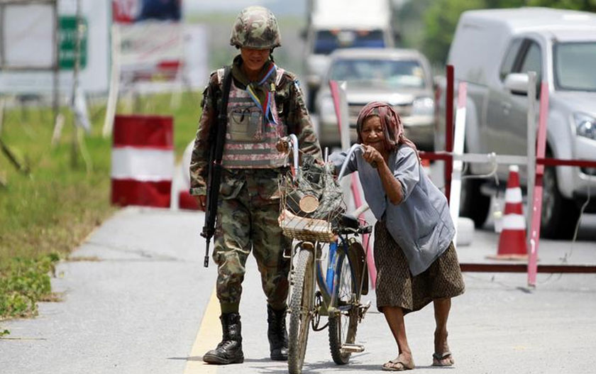 Seorang wanita tua sedang menolak basikalnya semasa melalui 'checkpoint' di Yala, Thailand. Foto ini dirakamkan pada 27 Mac 2013. Foto Reuters. (Gambar hiasan)