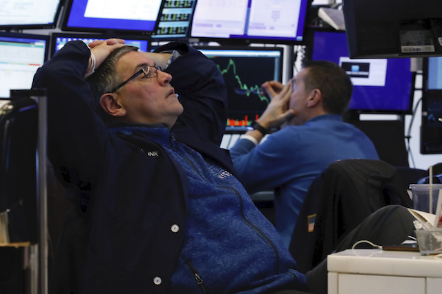 A pair of traders work in their booth on the floor of the New York Stock Exchange, Thursday, March 12, 2020. The deepening coronavirus crisis is sending stocks into another alarming slide on Wall Street, triggering a brief, automatic shutdown in trading for the second time this week. (AP Photo/Richard Drew)