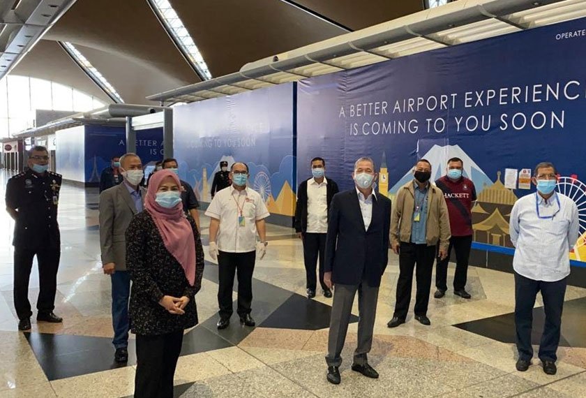 Noraini dan Fadillah mengamalkan penjarakan sosial selepas proses menghantar pelajar Sarawak di KLIA. - Foto Ihsan Rumah Sarawak