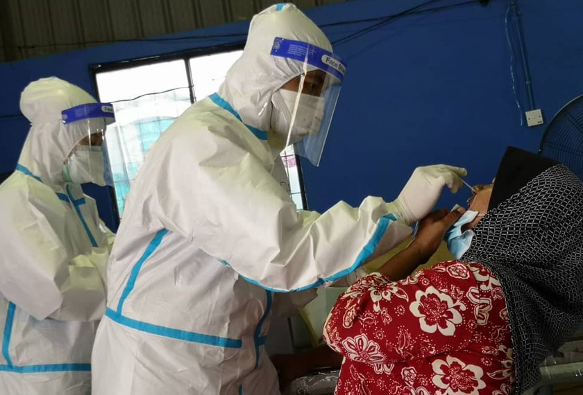 Petugas perubatan sedang memeriksa penduduk Kampung Tabuan Lot, Kuching.