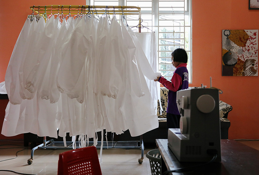 Nur Afia Qistina Zamzuri, a 9-year-old girl inspects a personal protective equipment (PPE) she made for free to medical workers working in local hospitals at her home, amid the coronavirus disease (COVID-19) outbreak, in Kuala Pilah
