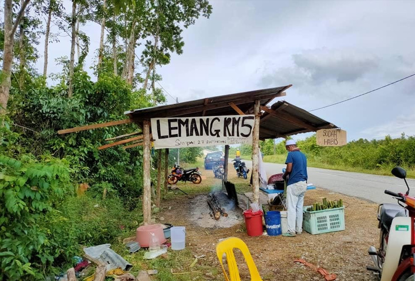 Muhamad Azmi menjual lemang bagi menambah pendapatannya sejak seminggu lalu berikutan harga getah yang semakin jatuh.