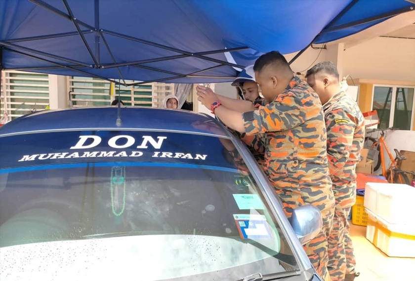 Anggota bomba membantu menyelamatkan seorang kanak-kanak yang terperangkap dalam kereta bapanya.