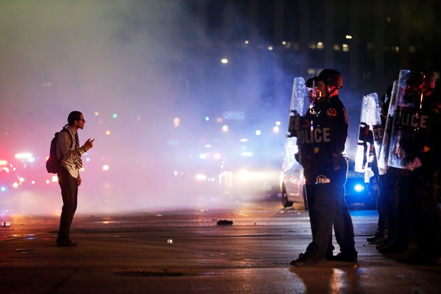 A protestor stands in the middle of the tear gas confronting tactical officers at the intersection of Young St. and S. Griffin St. in downtown Dallas, Friday, May 29, 2020. People marched in protest of the in-custody death of George Floyd when they confronted Dallas Police tactical officers. Floyd died after being restrained by Minneapolis police officers on Memorial Day.(Tom Fox/The Dallas Morning News via AP)