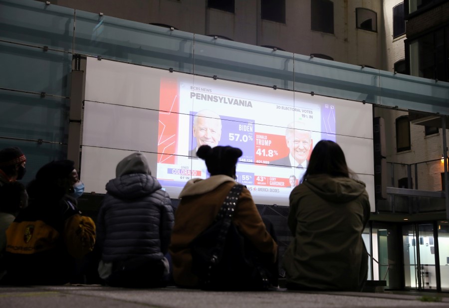 People watch early results come in from Pennsylvania, outside during Election Day in downtown Brooklyn, New York, U.S. November 3, 2020. REUTERS/Caitlin Ochs
