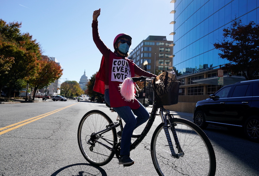 A woman rides her bike as she takes part in a protest the day after the 2020 U.S. presidential election in Washington, U.S., November 4, 2020. REUTERS/Erin Scott