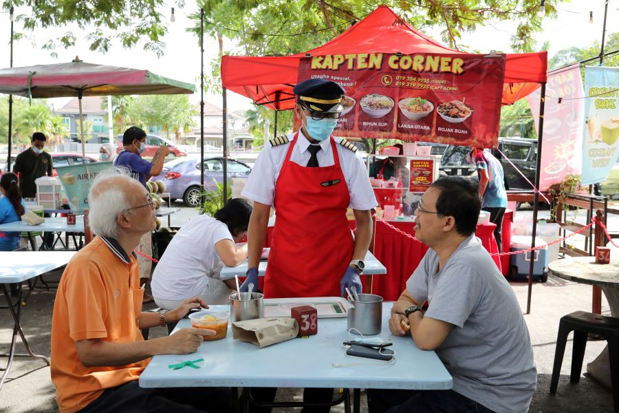 Malaysian former pilot Azrin Mohamad Zawawi talks to customers at his food stall in Subang Jaya, Malaysia November 7, 2020. REUTERS/Lim Huey Teng