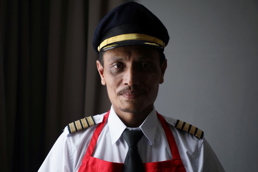 Malaysian former pilot Azrin Mohamad Zawawi poses for a picture with his uniform and apron, at his home in Subang Jaya, Malaysia November 7, 2020. REUTERS/Lim Huey Teng