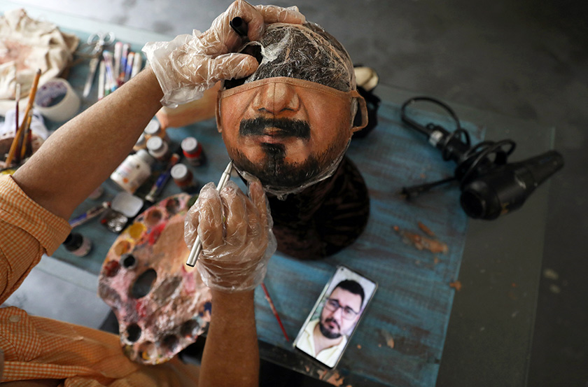 Roriz paints the person's lower face on to a white mask, taking time over the details like skin hue and lips. REUTERSpic