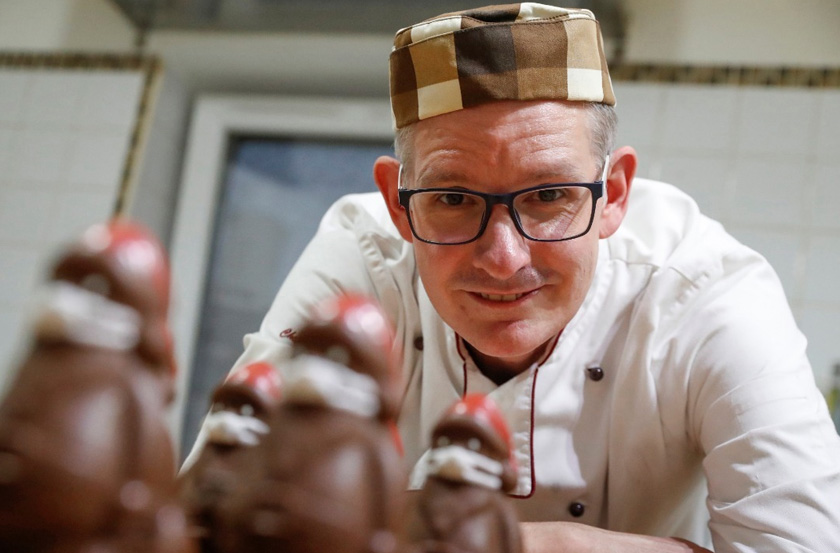Hungarian confectioner Laszlo Rimoczi poses with chocolate Santas wearing protective face masks at his workshop in Lajosmizse, Hungary. REUTERSpic