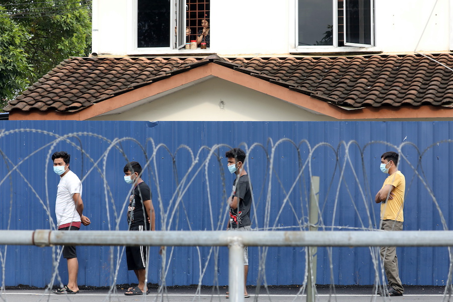 Top Glove workers wait in line for food distribution outside a hostel under enhanced lockdown, amid the coronavirus disease (COVID-19) outbreak in Klang, Malaysia November 17, 2020. REUTERS/Lim Huey Teng
