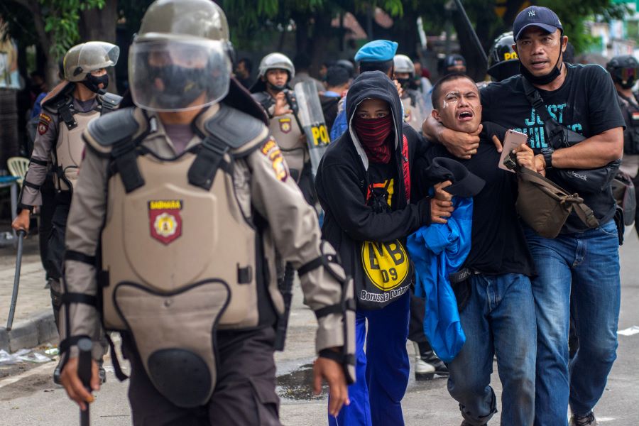 Plainclothes police officers detain a student-demonstrator during a protest against the government's proposed labour reforms in a controversial 