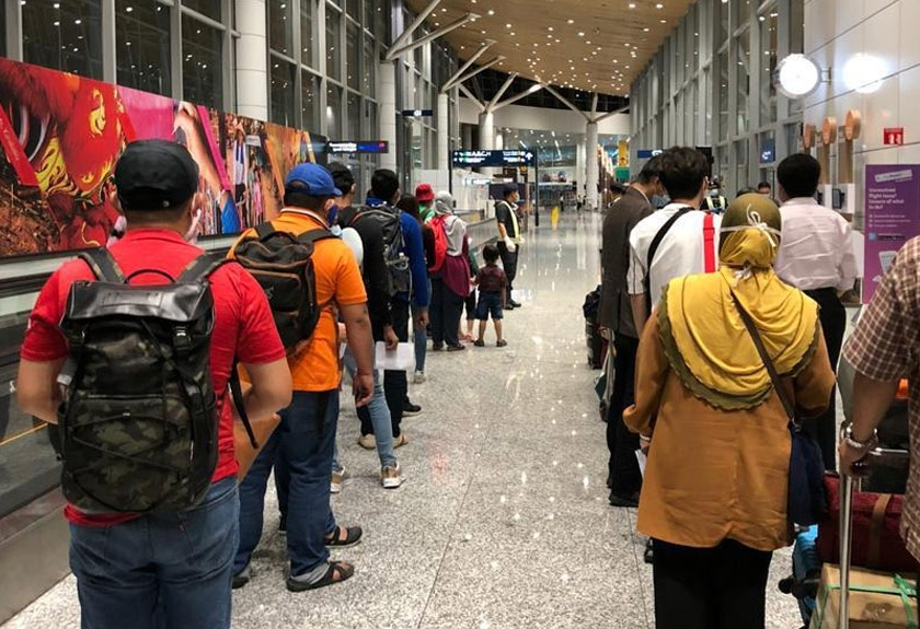 Para penumpang yang tiba dari Sabah beratur sebelum ke kaunter petugas KKM yang ditempatkan di Klia - Gambar Nazri Kahar/Astro AWANI