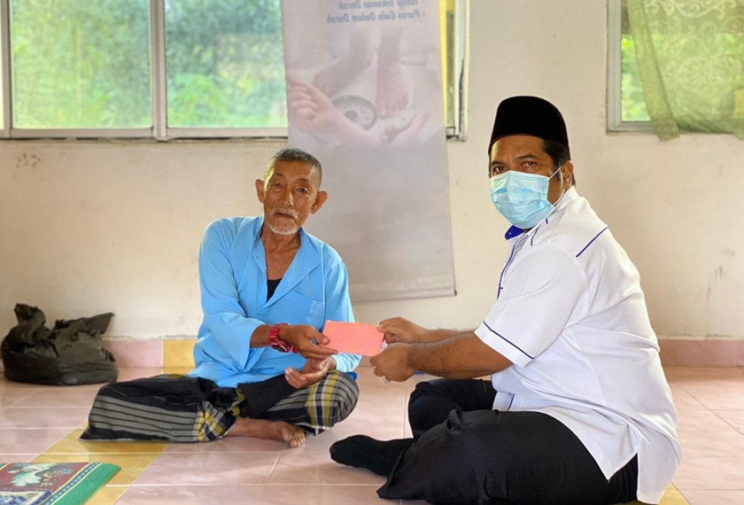 Guru Besar Sekolah Kebangsaan Santan, Musra Mat Saman (kanan) menyerahkan sumbangan kepada Hassan Ali.