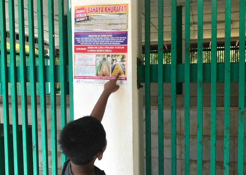 Poster Bahaya Khurafat dapat dilihat di kawasan perkuburan di Pulau Besar