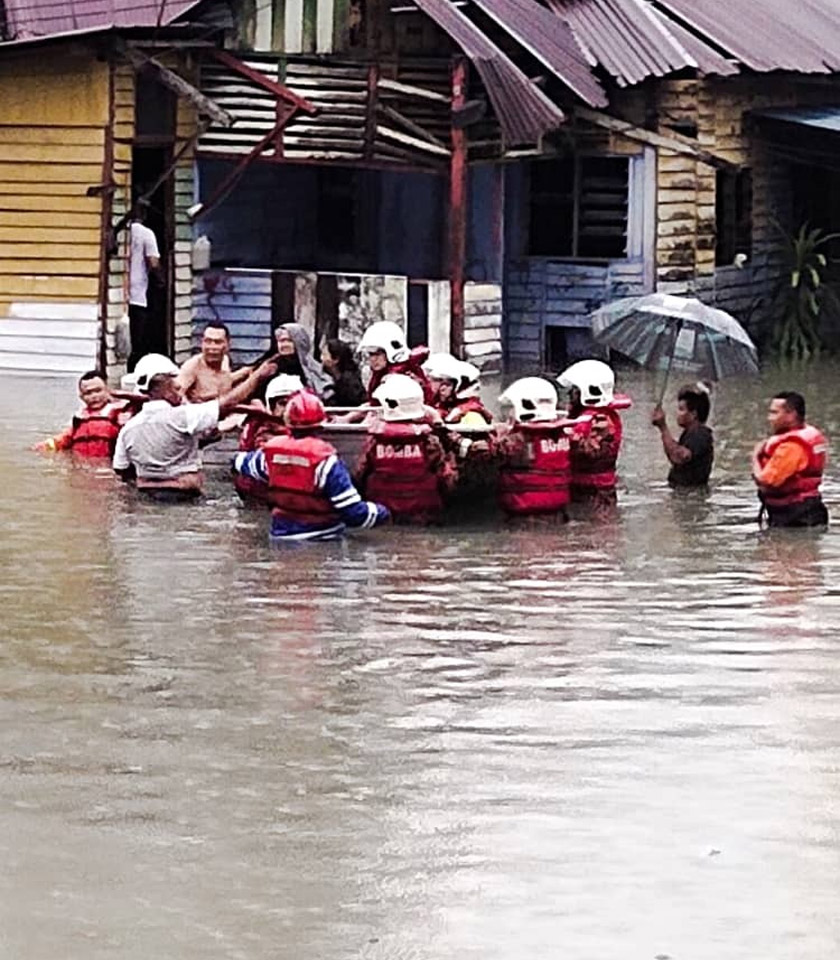 Anggota bomba membantu memindahkan mangsa yang terperangkap dalam banjir. - Foto JBPM KL