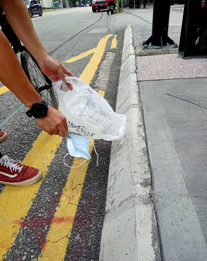 Rudy mengutip pelitup muka yang ditemui bersepah di jalanan dengan menggunakan penyepit. 