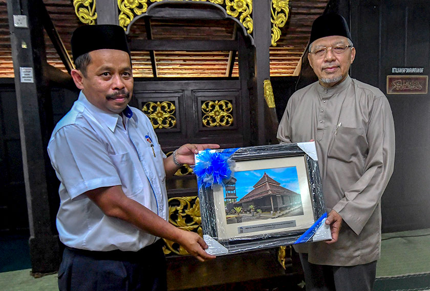 Ahmad (kanan) menerima cenderahati daripada Ketua Pegawai Eksekutif ECERDC Baidzawi Che Mat (kiri) selepas Majlis Doa Selamat Sempena Pemindahan Bangunan Asal Masjid Kampung Laut di Nilam Puri, 14 Sept, 2020. --fotoBERNAMA