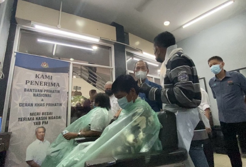 Tan Sri Muhyiddin bertanyakan sesuatu kepada Mahdi Hasbi, salah seorang penerima Bantuan Prihatin Nasional. - Foto Astro AWANI