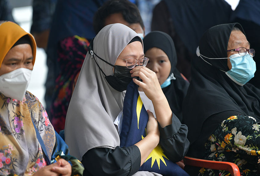 Balu Allahyarham Kpl U Sharif Mohd Siddiq Al-Attas Wan Sabli, Shima Mustapha, 29, (tengah) menahan sebak ketika menghadiri pengebumian jenazah suaminya di Tanah Perkuburan Kampung Melayu Seniawan Seberang dekat sini, hari ini. - Foto BERNAMA