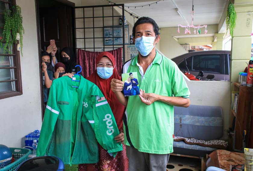 Norlis Husin (kiri) dan Mat Nazir Abu Hassan menunjukkan gambar Allahyarham kepada pemberita yang maut dalam kemalangan ketika dalam perjalanan menghantar makanan.