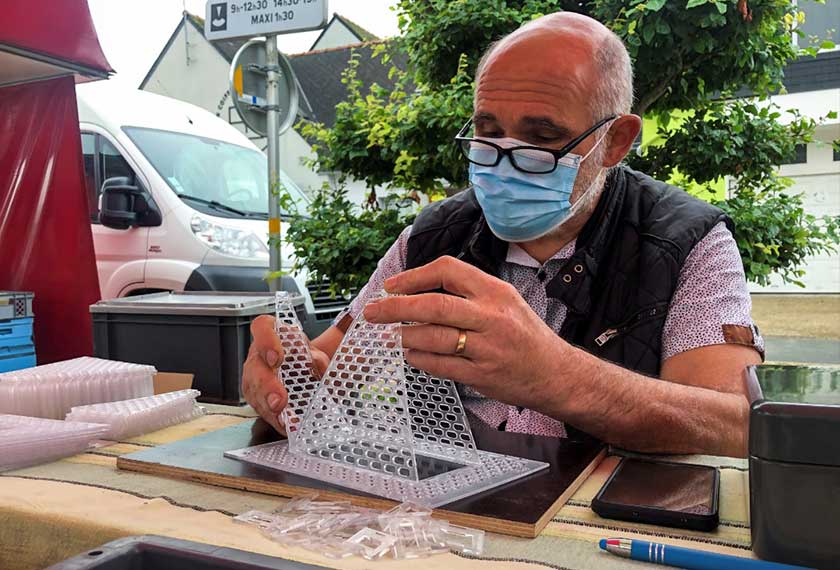 French beekeeper Denis Jaffre, inventor of a trap designed to catch Asian giant hornets, sits in a stall at a market in Pencran, France. -REUTERS