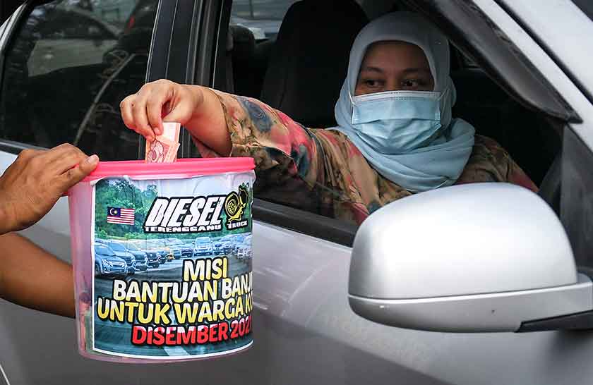 Orang awam menderma untuk tabung misi bantuan banjir secara pandu lalu bagi membeli barangan keperluan sebelum diagihkan kepada mangsa-mangsa terjejas banjir di pusat pengumpulan bantuan banjir di Pantai Batu Burok, 26 Dis 2021. --fotoBERNAMA.