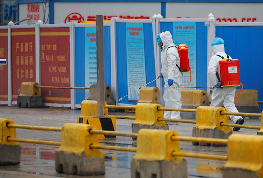 Workers in PPE spray the ground with diinfectant in Baishazhou market during a visit of World Health Organization (WHO) team tasked with investigating the origins of the coronavirus (COVID-19) pandemic, in Wuhan, Hubei province, China, January 31, 2021. - REUTERS