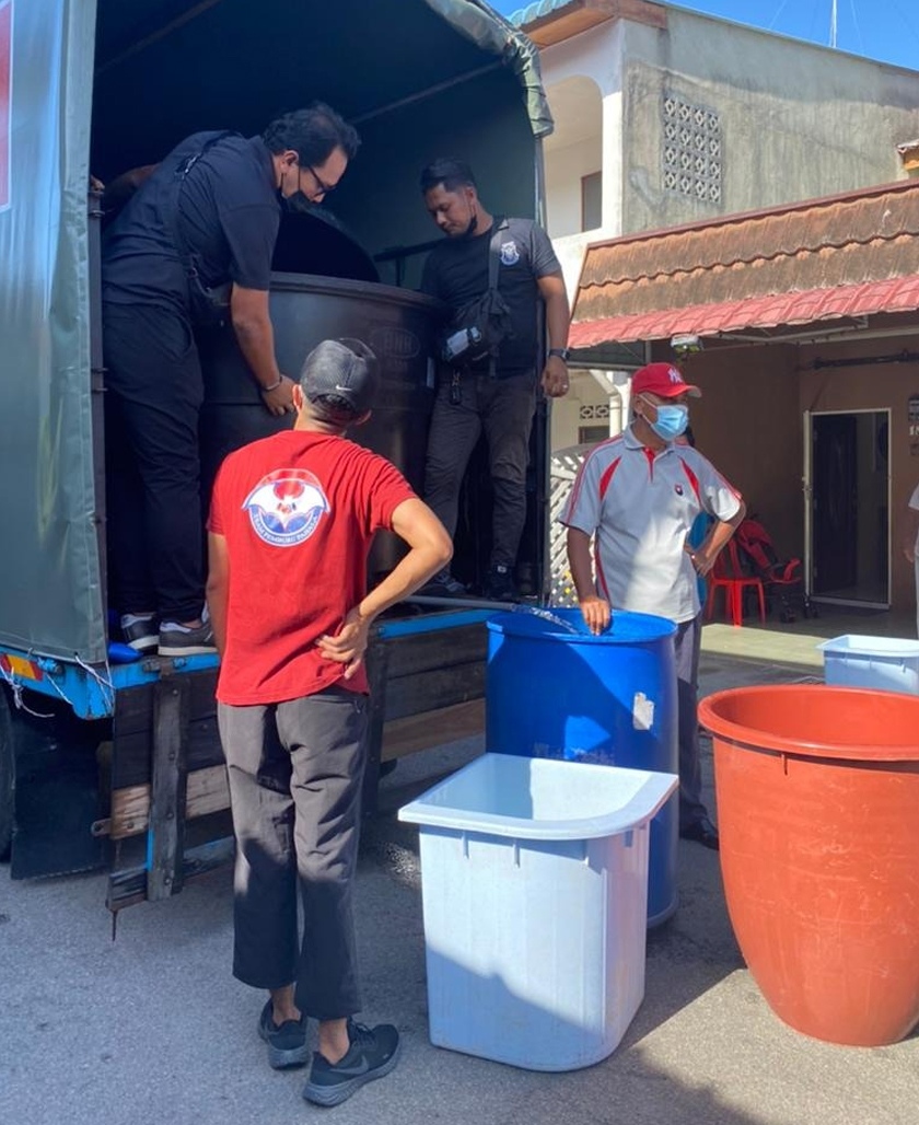 Shahrol bersama NGO Aku Budak Kluang menyalurkan bantuan air susulan masalah gangguan air di daerah Kluang sejak empat hari lalu - Gambar ihsan Shahrol Shiro