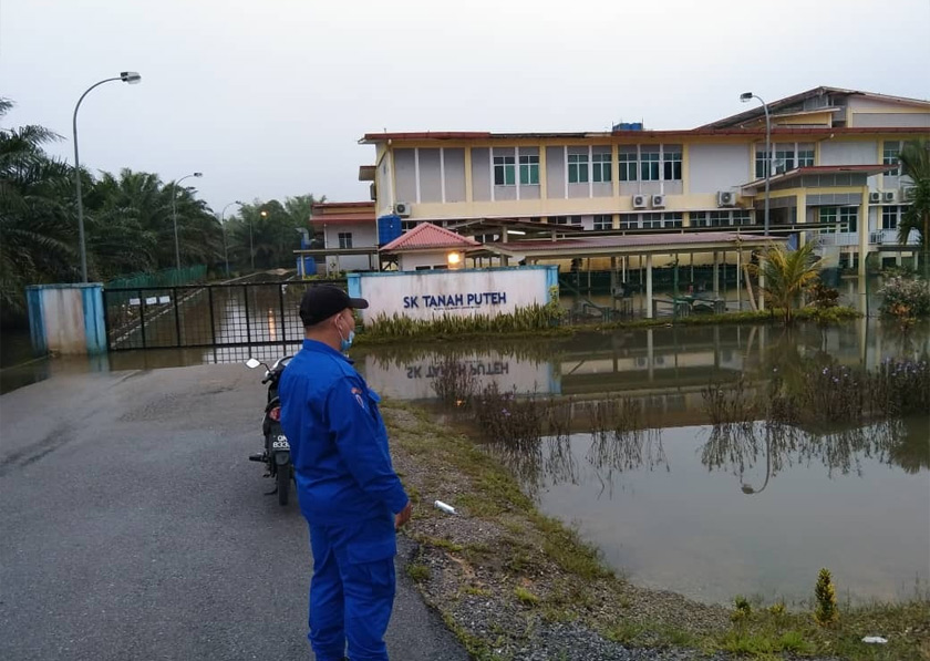Anggota APM Sarawak meninjau keadaan paras air di Kampung Tanah Puteh, Serian.