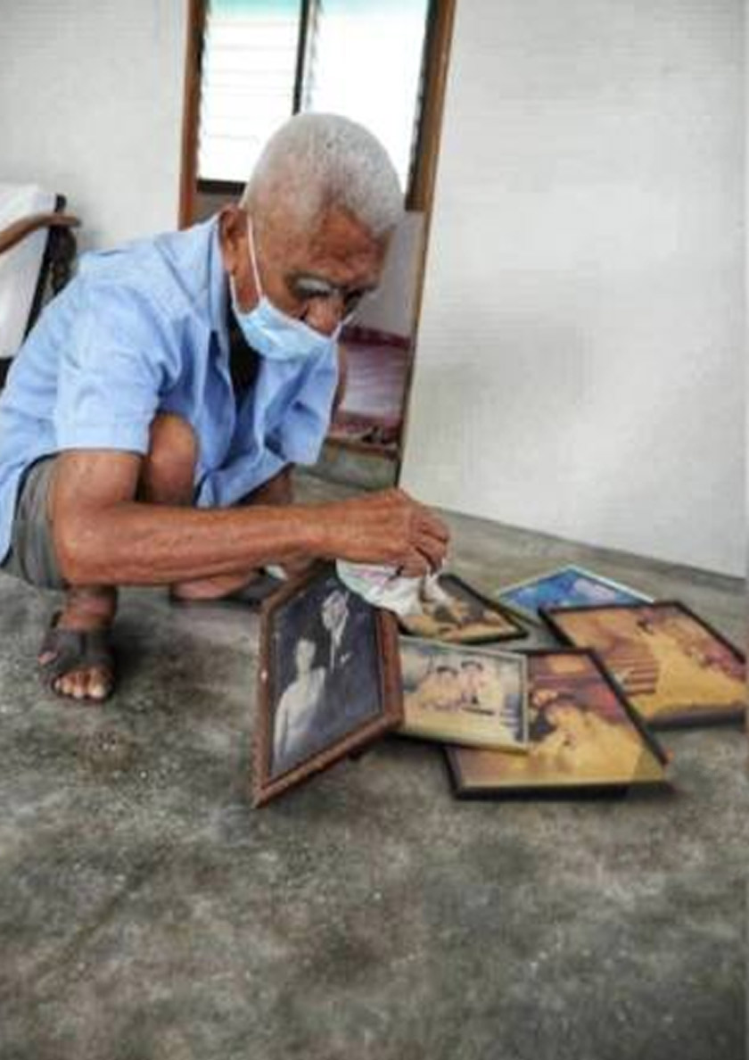 Lean Ngang membersihkan gambar lama keluarga mereka untuk digantung di dinding rumah. - Foto Sinar Harian