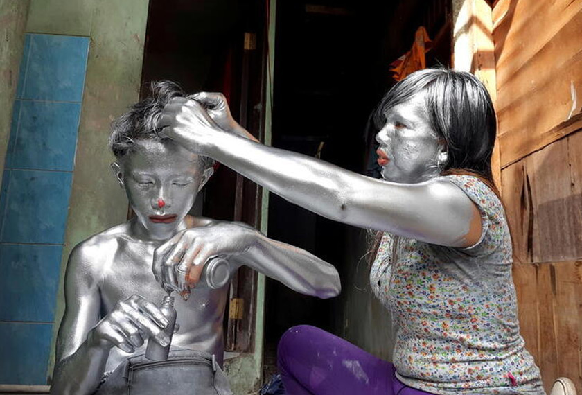 Puryanti, a 29-year-old woman, and her 15-year-old nephew Raffi, cover themselves from head to toe in silver paint to become 'manusia silver' (silver people), as part of their act to make a living, in Depok, on the outskirts of Jakarta, Indonesia. REUTERSpic