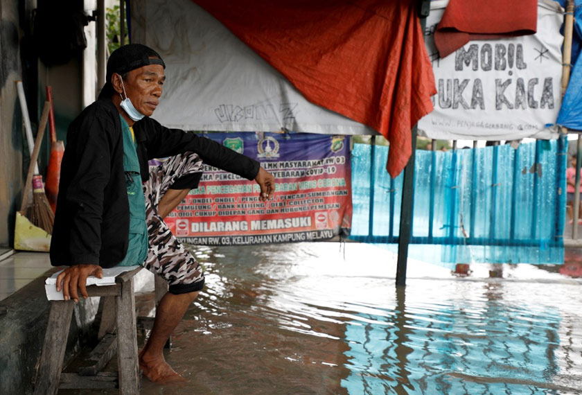 Seorang penduduk tempatan pasrah melihat kenaikan paras air akibat banjir di Jakarta. - Reuters