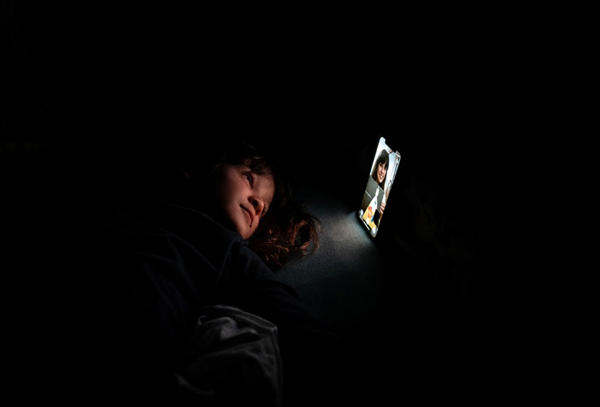Bianca Toniolo, smiles as she has a video call with her mother Chiara Zuddas, 32, who is self-isolating in a bedroom after having contact with someone with coronavirus disease (COVID-19), in this picture taken by Bianca's father who is also in quarantine at home with his family in San Fiorano, Italy. via REUTERS