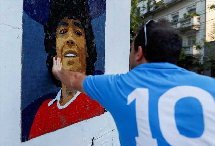A man touches a mosaic made by the cultural orgaization Comado Maradona as a homage to late Argentine soccer superstar Diego Armado Maradona, in Buenos Aires, Argentina February 25, 2021. REUTERSpic